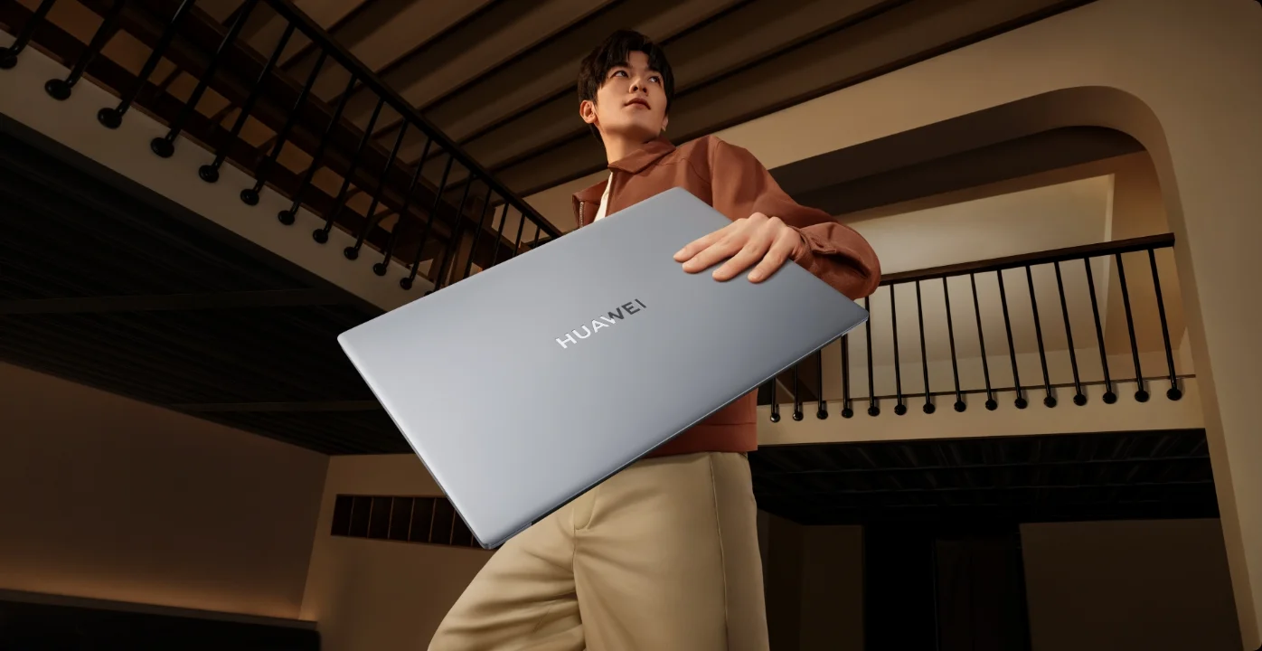 A man carrying the silver laptop