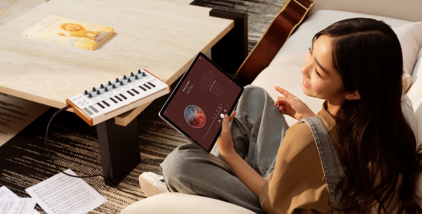 A woman listening to music on the tablet