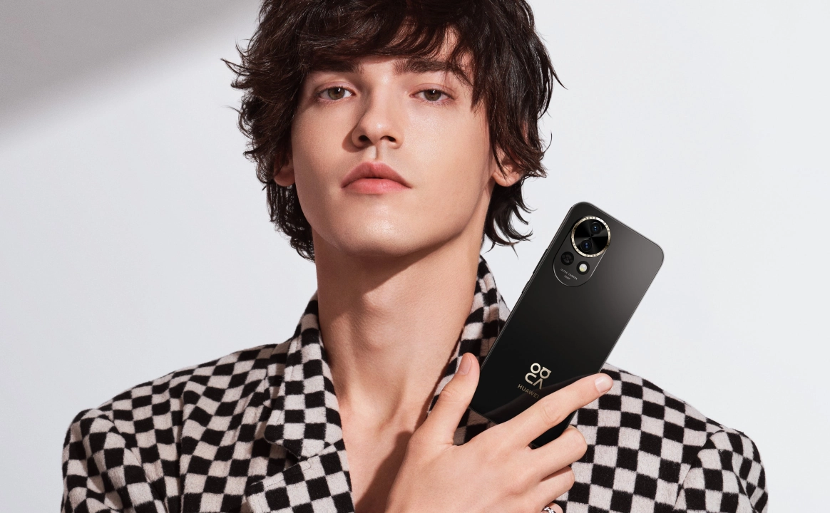 A young man holding a Black HUAWEI nova 13